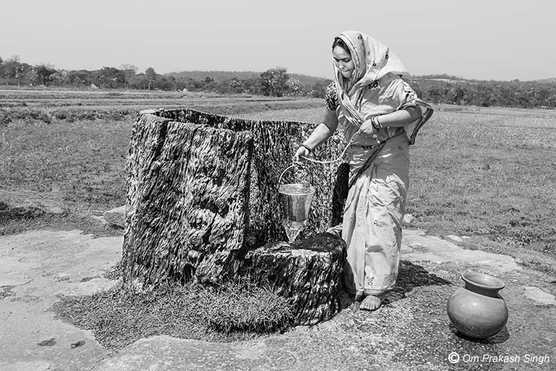 Collecting water in the middle of the day from Kukuru Daarhi at Jiuri village, Jharkhand, India